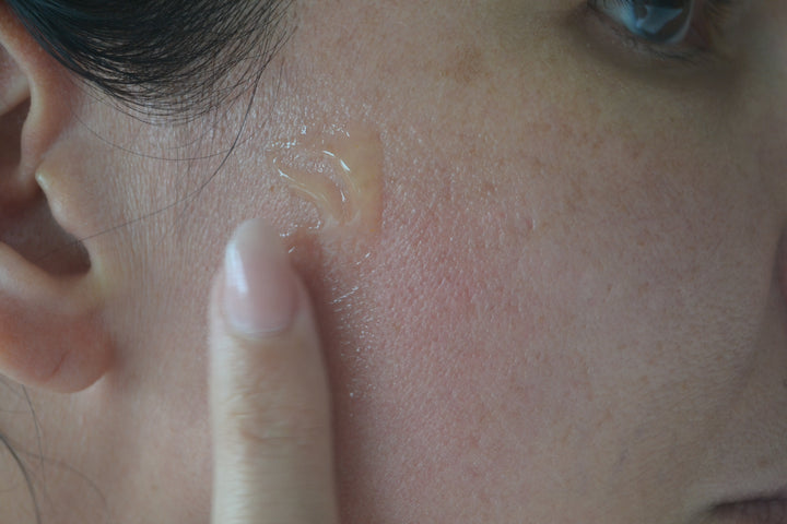 Model applying Cx3 Gold Serum to face by EMK Skincare