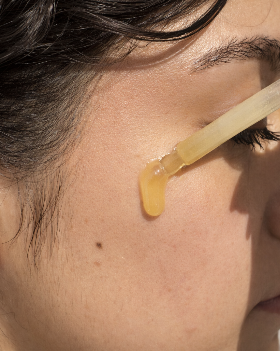 Model applying Cx3 Gold Serum — antioxidant defense 