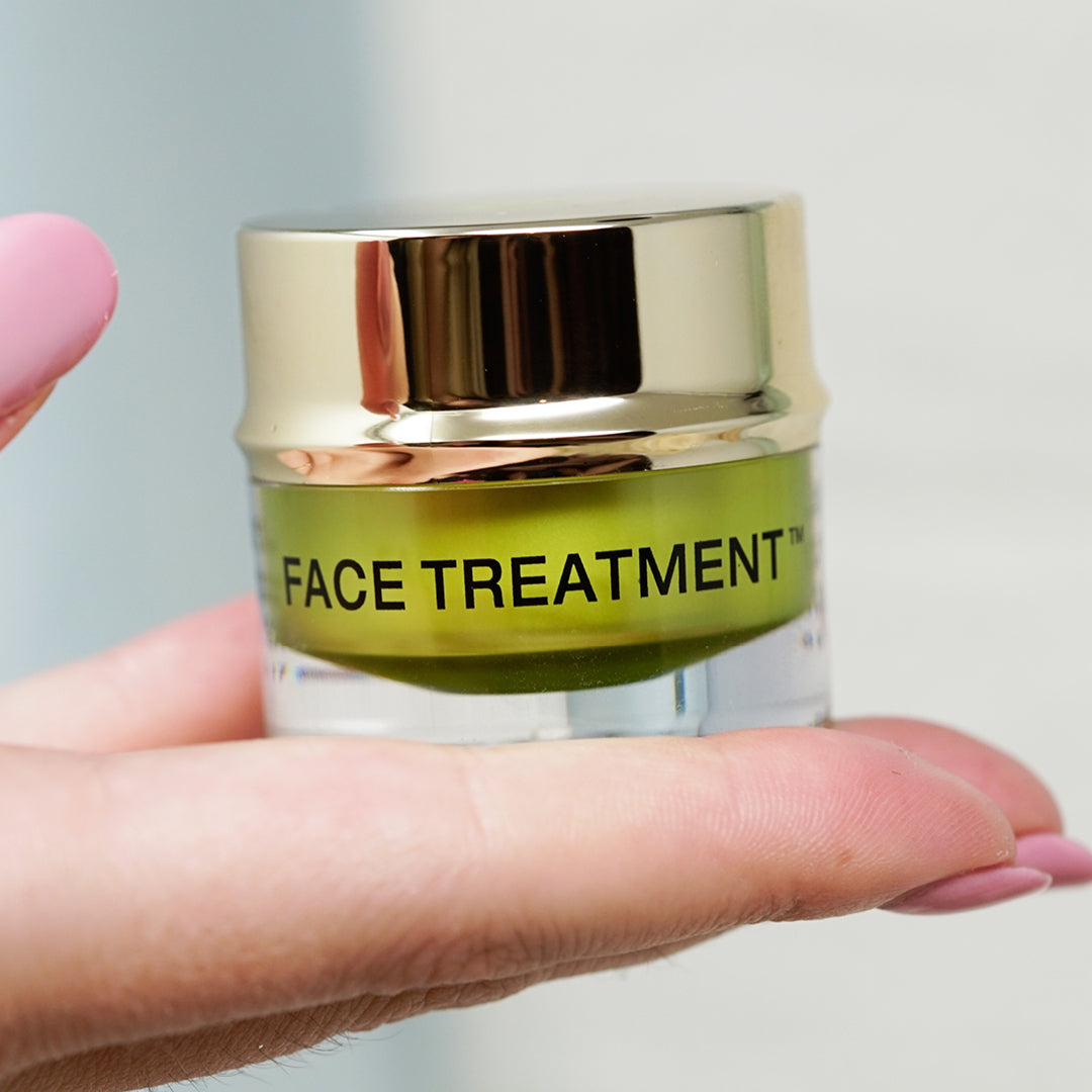 Face Treatment jar held in hand by EMK Skincare
