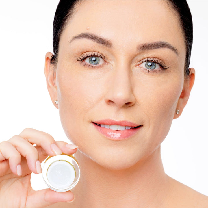 Model holding Face Treatment open jar by EMK Skincare