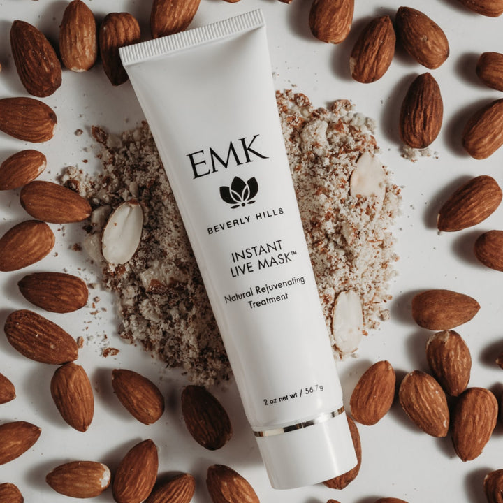 Instant Live Mask tube styled with crushed almonds by EMK Skincare