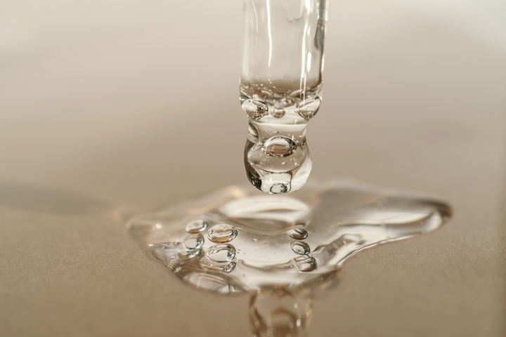 Rescue Serum dropper dripping onto a puddle by EMK Skincare