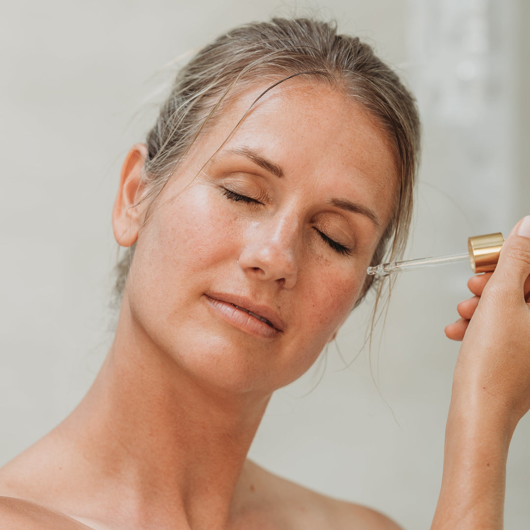 Model applying Rescue Serum for barrier recovery by EMK Skincare